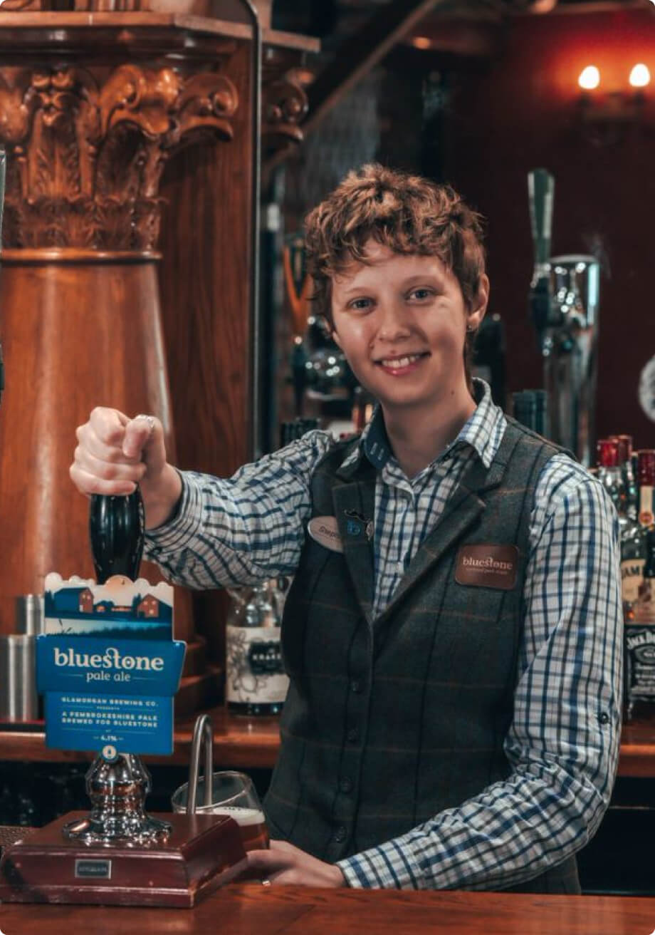 Bartender smiling while is taking a beer