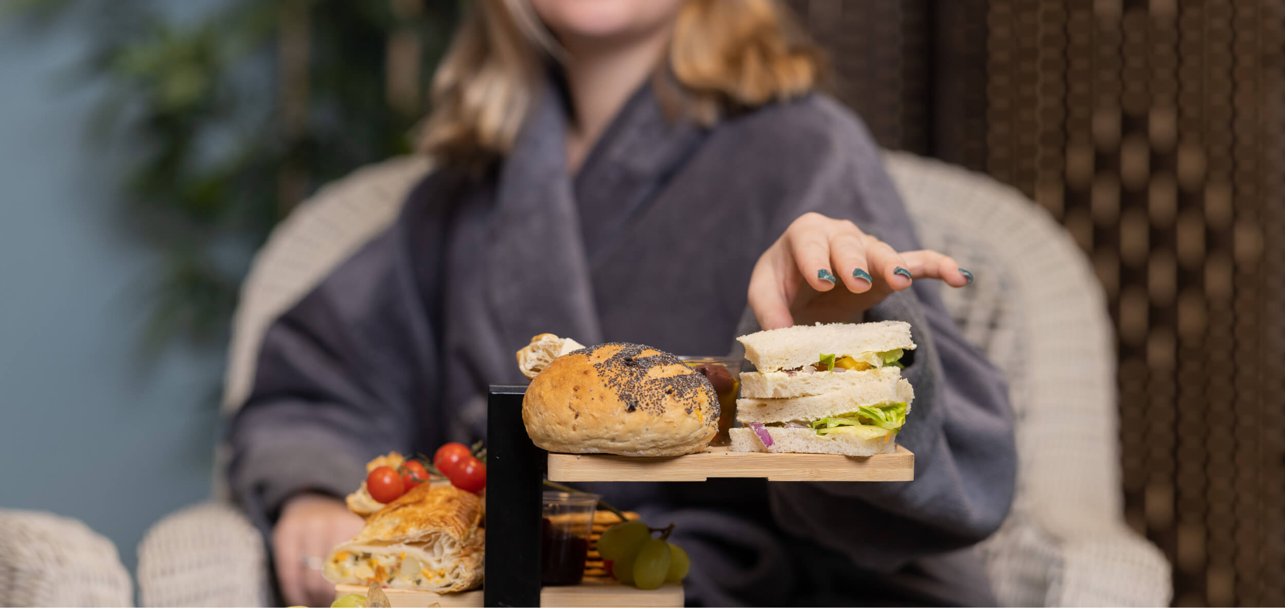 Woman grabbing a sandwich from the table