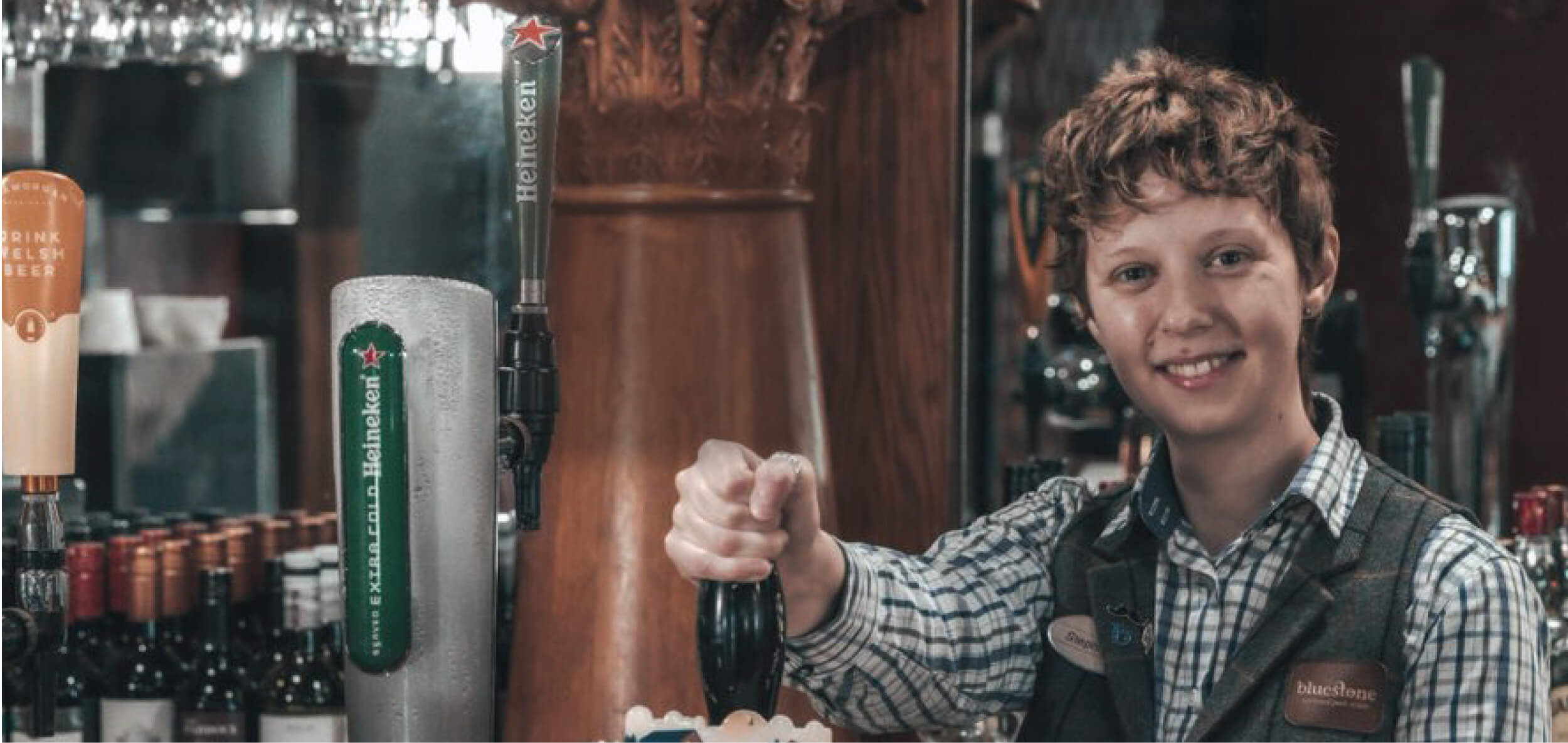 Bartender smiling while is taking a beer