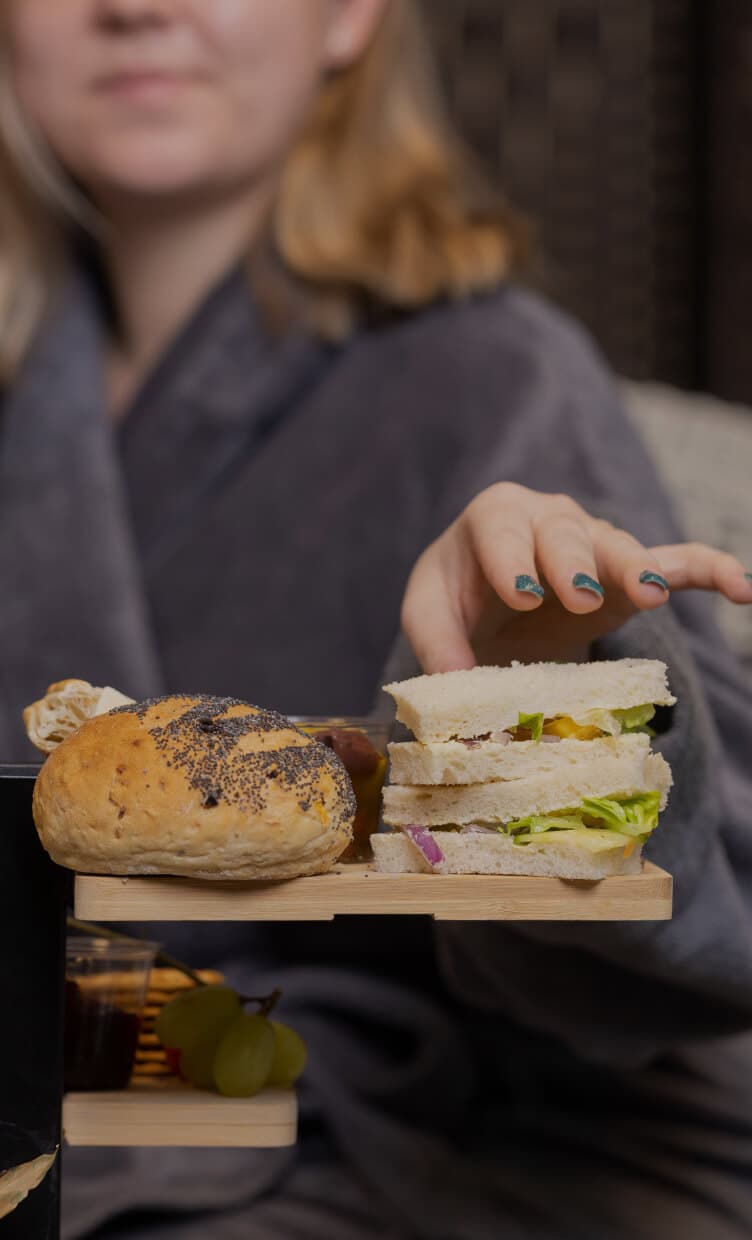 Woman grabbing a sandwich from the table