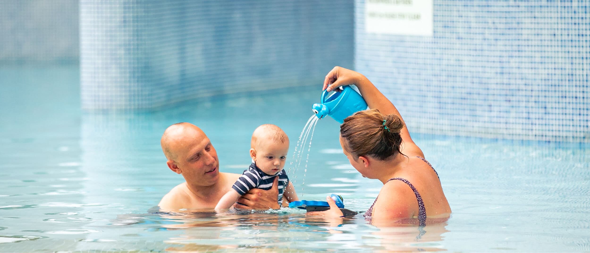 Couple with a baby enjoying the pool 