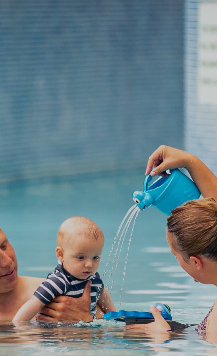 Couple with a baby enjoying the pool
