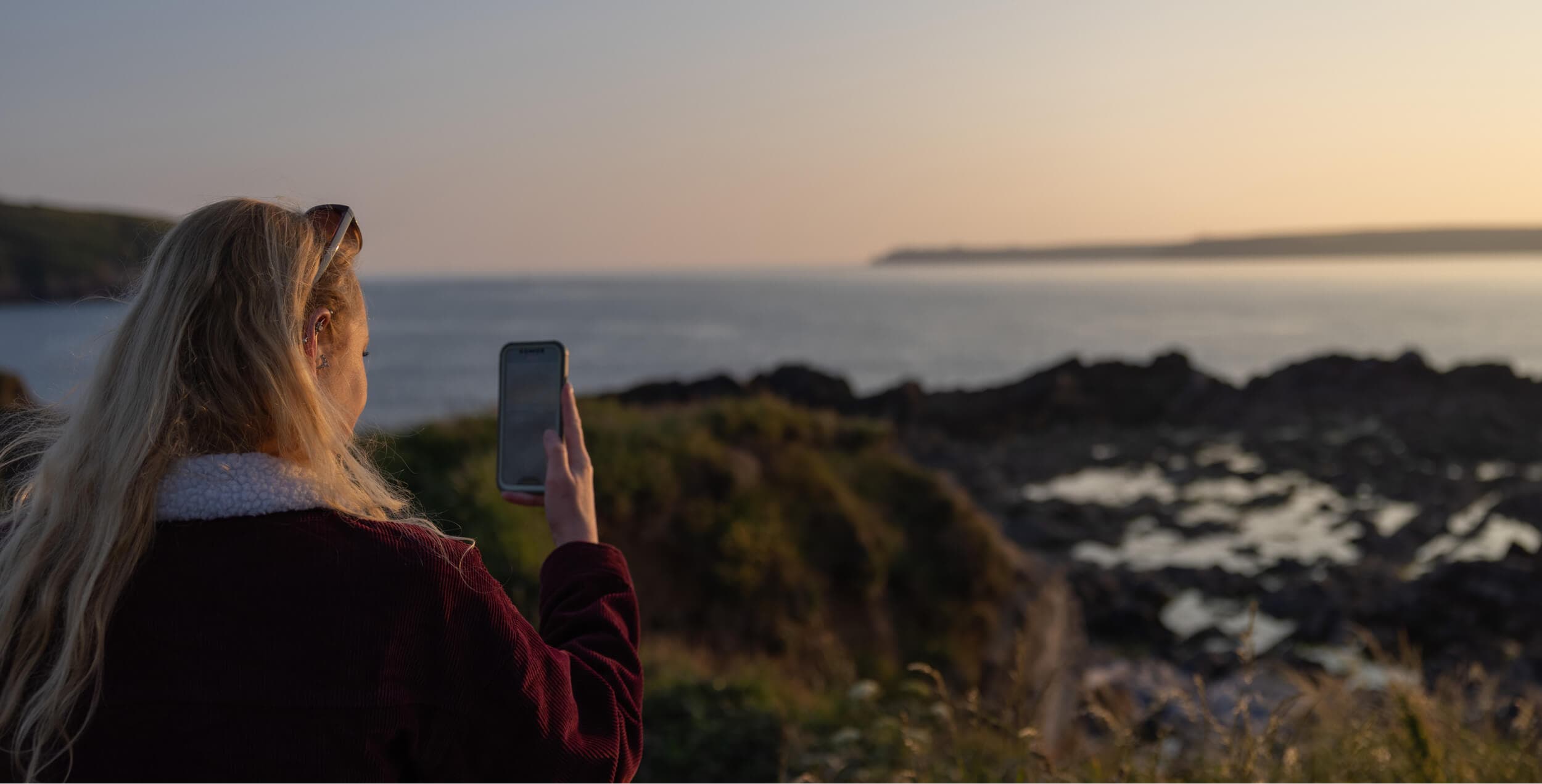 Girl taking a photo of the landscape with a smartphone
