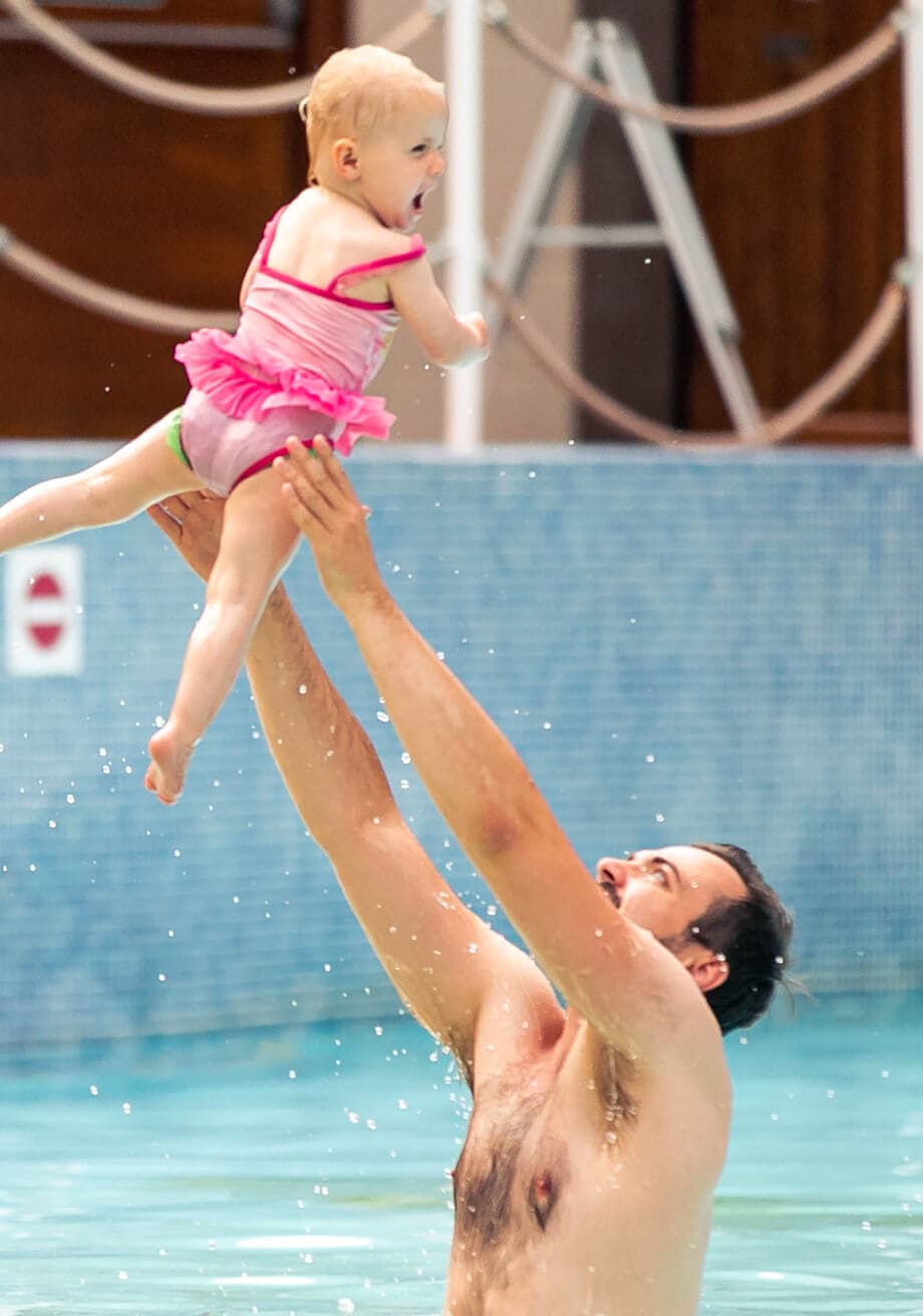 Father playing with child in the pool 