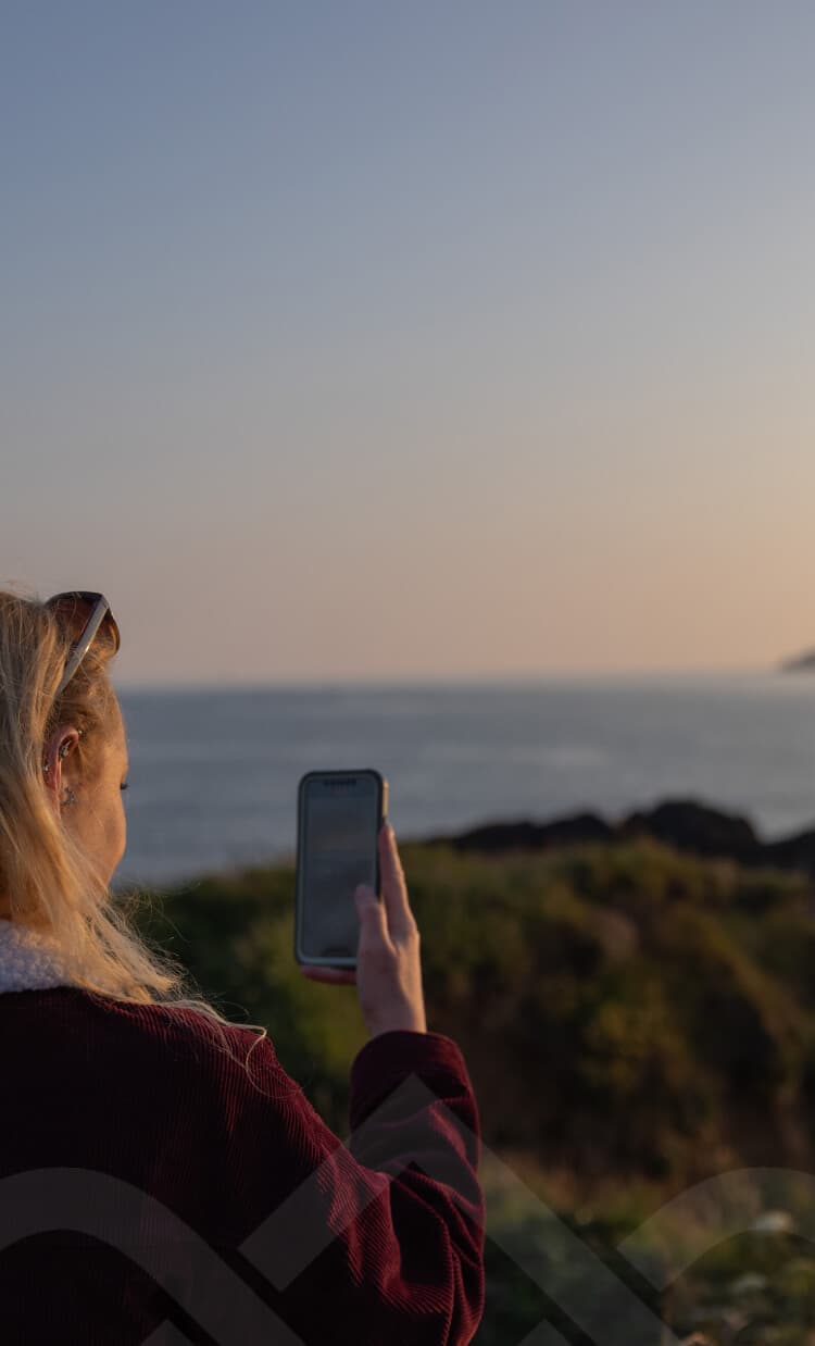 Girl taking a photo of the landscape with a smarthphone